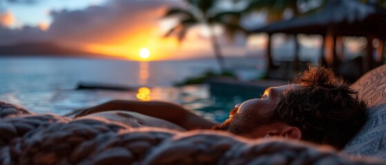Wall Mural -  A man reclines in a hammock before a tranquil body of water, framed by a breathtaking sunset
