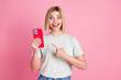 © deagreez - Portrait of charming impressed girl with bob hair wear white t-shirt indicating at smartphone staring isolated on pink color background