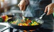 © Nadin Faust - close up of hands cooking vegetables in a wok on a stove at home, using fork and spoon, colorful vegetable mix, healthy breakfast, high quality photo, blurred background