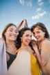 © Jose Calsina - Vertical. Three young women having fun taking a selfie portrait on their beach summer vacations. Group of only females wearing swimsuit shooting a photo, enjoying a a weekend on the coast