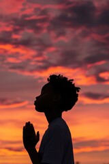 Canvas Print - A person stands in front of a beautiful sunset with warm colors and clouds