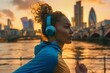 © Elmira - A close-up photograph of a woman runner in action, wearing headphones and sprinting along a city riverbank at sunset