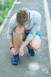 © be free - Fitness man tie shoelaces outdoor. Fitness man tying lace of his sports shoes. Athlete getting ready for workout wearing shoes at the floor. Sportsman tying sneakers. Athletic shoes