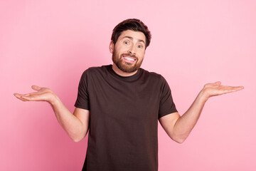 Wall Mural - Portrait of clueless man with bristle stylish hairdo wear brown shirt hold palms up shrug shoulders isolated on pink color background