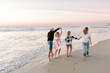 © Erin Brant/Stocksy - Happy Family with teenagers on the beach together
