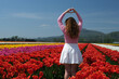 © Oleksandra - Attractive woman in a nice flowery dress walking through endless tulips field in spring. Aerial view of colorful tulips in bloom and girl. Concept: Tulips in Keukenhof gardens, Netherlands, Holland.