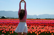© Oleksandra - Attractive woman in a nice flowery dress walking through endless tulips field in spring. Aerial view of colorful tulips in bloom and girl. Concept: Tulips in Keukenhof gardens, Netherlands, Holland.