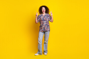 Wall Mural - Full length photo of lovely young lady show v-sign dressed stylish colorful garment isolated on yellow color background