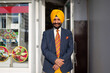 © Hernandez & Sorokina/Stocksy - Indian Business Owner In Front Of His Shop