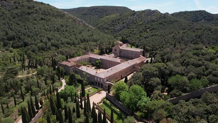 Wall Mural - Forward reveal aerial shot of Fontfroide Abbey on sunny day. Narbonne, France.