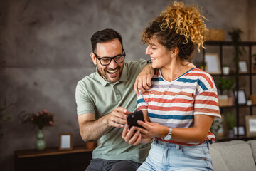 Wall Mural - adult couple husband and wife enjoy and use mobile phone together