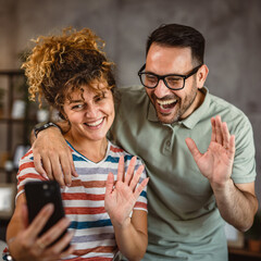 Wall Mural - adult couple have a video call or take self portrait on mobile phone