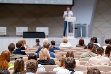 Wall Mural - Tech conference with speaker and audience in a modern venue. People networking, sharing ideas, and learning about new technology trends.