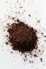 Poster - A pile of dirt sits on a white surface, perfect for use in editorial or design contexts where a natural texture is needed