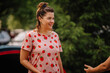 © Raivo - limbazi, Latvia, June 29, 2024 - Woman in a strawberry-patterned shirt smiling outdoors, blurred background, casual and cheerful atmosphere.