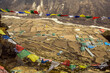 © Irina Bo/Stocksy - Colorful prayer flags over Himalayan high altitude village and fields