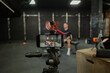 © Raul Navarro/Stocksy - Behind-the-scenes fitness vlogging setup in gym