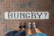 © Maryanne Gobble/Stocksy - Hungry Sign on City Sidewalk