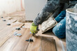 © Ezequiel Giménez/Stocksy - Crop workman installing wooden tile in room with adhesive material