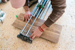 © Ezequiel Giménez/Stocksy - Crop handyman cutting wooden tile with cutter during flooring work
