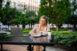 © DZ FILM/Stocksy - A woman uses a laptop sitting outdoors