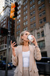 © DZ FILM/Stocksy - A woman drinks coffee standing on a city street