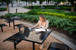 © DZ FILM/Stocksy - A woman uses a laptop sitting outdoors