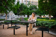 © DZ FILM/Stocksy - A woman uses a laptop sitting outdoors