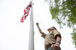 © Raymond Forbes LLC/Stocksy - Senior Citizen military War Veteran Raising American Flag at flagpole