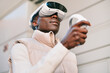 © VICTOR TORRES/Stocksy - Man wearing virtual reality headset in urban setting