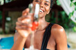 © David Prado/Stocksy - Radiant woman enjoying a glass of champagne at a poolside