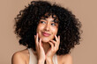 © mahalo studio/Stocksy - woman with curly hair smiling thoughtfully
