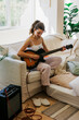 © BONNINSTUDIO/Stocksy - Serene woman practice guitar at home