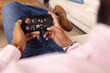 © Wavebreak Media - Holding smartphone, man relaxing on couch and playing game at home