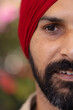 © Wavebreak Media - Close-up of Indian man with red turban, smiling and looking at camera
