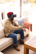 © Wavebreak Media - Using VR headset, man sitting on sofa and interacting with virtual environment