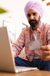 © Wavebreak Media - Holding credit card, man using laptop for online shopping at home