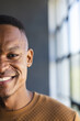 © Wavebreak Media - Smiling man in casual attire standing indoors near large window