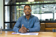 © Wavebreak Media - Businessman sitting at desk with documents, looking confident in modern office