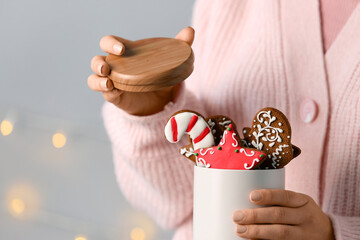 Sticker - Woman with Christmas gingerbread cookies on grey background