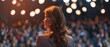 © wpw - A confident businesswoman stands in front of a large audience and delivers an engaging presentation.