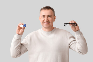 Sticker - Happy mature man with contact lens case and eyeglasses on grey background