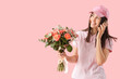 © Pixel-Shot - Young delivery woman with bouquet of beautiful flowers talking by mobile phone on pink background