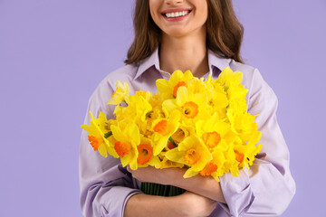 Wall Mural - Beautiful young woman with daffodils on lilac background, closeup