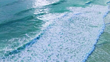 Wall Mural - Beautiful sea summer landscape, Waves sea water surface High quality video Bird's eye view, Drone top view waves crashing on sand beach,Nature ocean sea beach background