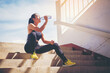 © Panumas - Tired runner woman with a bottle of electrolyte drink freshness after training outdoor workout at the stadium stairway.