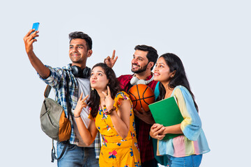 Indian asian young college students using smartphone for video or selfie photograph against white background
