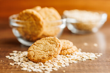 Poster - Tasty oatmeal cookies and rolled oat on wooden table.