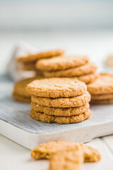 Poster - Tasty oatmeal cookies on cutting board on white table.