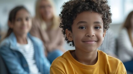 A young boy with a warm smile looks directly at the camera, surrounded by a group of people in the background.